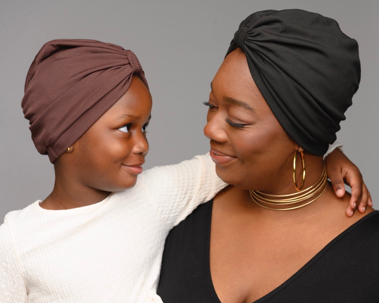 Woman and child wearing brown and black turbans