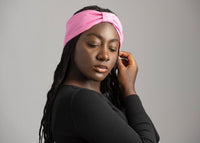 Adult woman with braids wearing a bright pink bowless headband