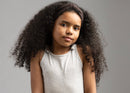 Child girl with long curly hair wearing a brown bowless headband