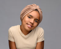A child wearing a mocha -  light brown satin lined turban