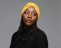 Female Model with braids wearing a satin-lined mustard turban